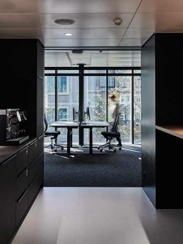 Die Büroflächen sind als Open Space konzipiert und mittig durch eine Begegnungszone, unter anderem mit Teeküche, unterteilt. Abbildung: Mint Architecture
